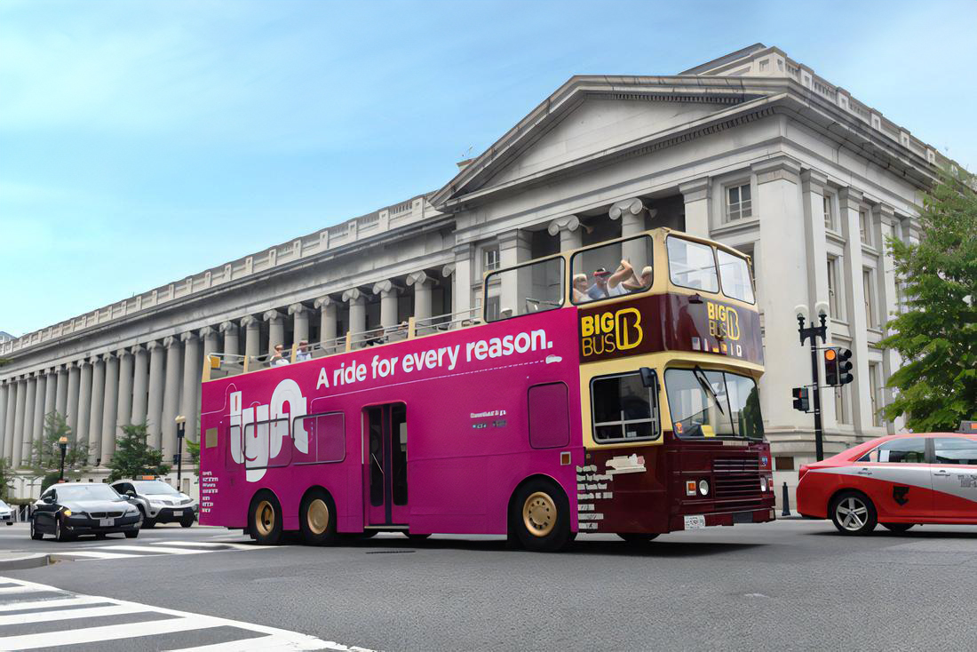 Lyft double-decker bus wrap advertisement in San Francisco featuring Driving You Happy campaign branding